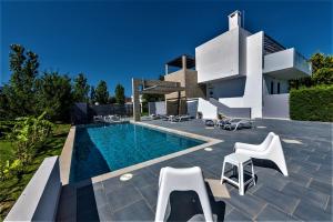 a villa with a swimming pool in front of a house at Xenos Villa 1 With Private Swimming Pool, Near The Sea in Tigaki