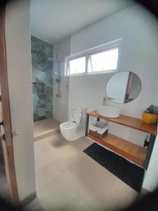 La salle de bains est pourvue de toilettes, d'un lavabo et d'un miroir. dans l'établissement Rooftop apartment, à Port-Louis