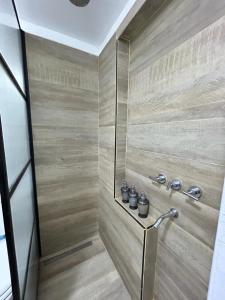 a bathroom with a shower with wooden walls at Aromos Lodge ll - Chacras de Coria in Ciudad Lujan de Cuyo