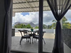 a table and chairs on a patio with a view at Rooftop apartment in Port Louis