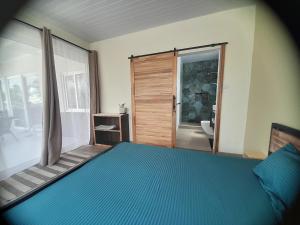 a bedroom with a blue bed and a door to a bathroom at Rooftop apartment in Port Louis