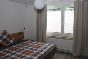 a bedroom with a bed and two windows at FeWo Oda in Bad Gandersheim