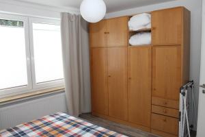 1 dormitorio con 1 cama y armario de madera en FeWo Oda, en Bad Gandersheim