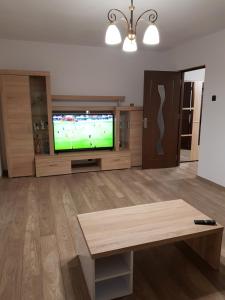 a living room with a flat screen tv and a table at Apartamentul Maria in Oradea