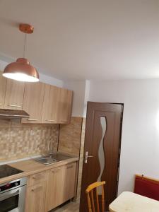 a kitchen with wooden cabinets and a sink and a refrigerator at Apartamentul Maria in Oradea +1 photo