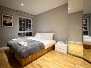 a bedroom with a large bed and two windows at David’s Place in EastEnd in London