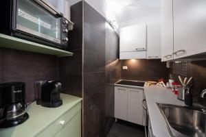 een kleine keuken met witte kasten en een spoelbak bij Casa Bartolomeo - Loft in Trastevere in Rome