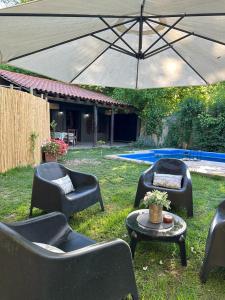 a group of chairs and tables under an umbrella at Aromos Lodge ll - Chacras de Coria in Ciudad Lujan de Cuyo +26 photos