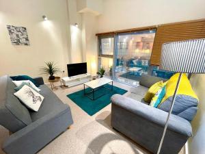 a living room with two couches and a television at April Disc - Long Stay - Contractors in Swindon