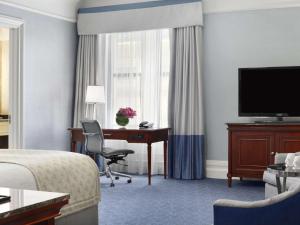 Habitación de hotel con cama, escritorio y TV. en Fairmont Copley Plaza, en Boston