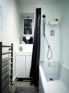 a bathroom with a shower and a bath tub at David’s Place in EastEnd in London