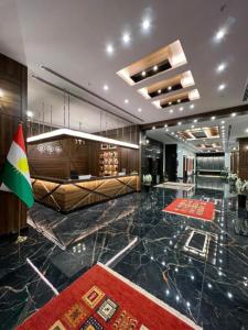 a lobby with a flag in the middle of a building at Hotel Classy Stay in Erbil