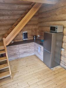 a kitchen in a log cabin with a refrigerator at Lebola Puhkemaja in Kasaritsa