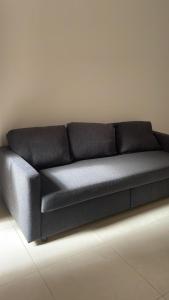 eine schwarze Couch, die an einer weißen Wand sitzt in der Unterkunft Appartamento viale della stazione in Spoleto