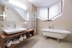 La salle de bains est pourvue d'une baignoire, d'un lavabo et d'une fenêtre. dans l'établissement Hotel Michael's Palace, à Košice