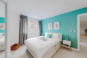a bedroom with a large bed with a blue wall at Modern and spacious 4 bed house in the city centre in London