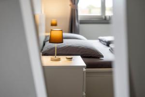 a bedroom with a bed and a lamp on a table at FerienwohnungHeimatgefühl in Rimpar