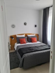 - une chambre avec un grand lit et 2 oreillers rouges dans l'établissement Luxe et Détente Près du Luxembourg, 