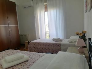 een slaapkamer met 2 bedden en een raam bij Le stanze della villa in Sambuca di Sicilia