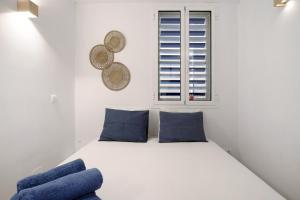 um quarto com uma cama com almofadas azuis e uma janela em Bajondillo Playa em Torremolinos