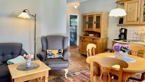 Il comprend une cuisine et un salon avec une table et des chaises. dans l'établissement Haus Strandgut FW 3, à Ahrenshoop