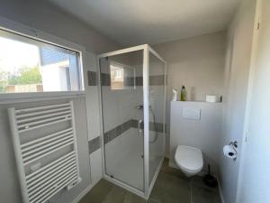 La salle de bains est pourvue d'une douche en verre et de toilettes. dans l'établissement Studio au calme avec jardin et stationnement, à Vannes