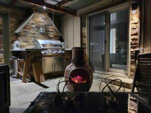 cocina al aire libre con chimenea y fogones en Anthropocene Jewel Cottage en Milton