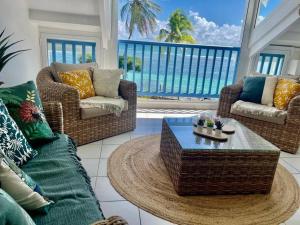 a living room with a view of the ocean at Ti MACLOA - Appartement les pieds dans l'eau in Sainte-Anne