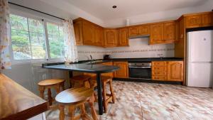 uma cozinha com armários de madeira, uma mesa e bancos em Casa Oneida em Valle Gran Rey