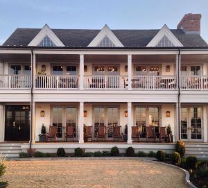 a large white house with windows and balconies at Baron's Cove in Sag Harbor