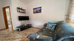 uma sala de estar com um sofá e uma televisão em Casa Oneida em Valle Gran Rey