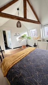 um quarto com uma cama grande num quarto com janelas em Het achterdek em Zwolle