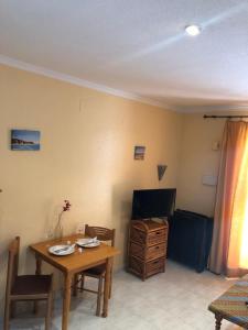 a living room with a table and a television at Vera Natura Urbanización Naturista in Vera