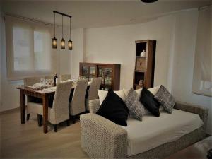 a living room with a couch and a table with chairs at Apartamento El Rinconzuelo in Rubielos de Mora
