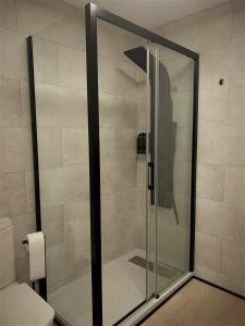 a glass shower in a bathroom with a toilet at Apartamento El Rinconzuelo in Rubielos de Mora +12 photos