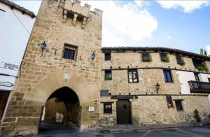 un gran edificio de piedra con un arco en Apartamento El Rinconzuelo en Rubielos de Mora