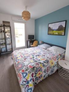 - une chambre avec un lit et une couette colorée dans l'établissement Appartement lumineux 4P/Terrasse, à Saint-Ouen