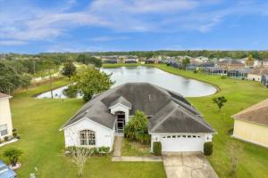 an aerial view of a house with a pond at 4 Bathrooms 3 Bathrooms Cresent Lakes 5305 Cv in Kissimmee