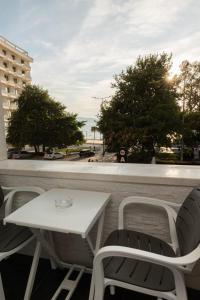uma mesa branca e cadeiras numa varanda com vista em Aglon Twin's Hotel em Vlorë