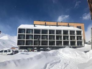a building with a lot of snow in front of it at 7 Senses Vista 1 BD Apartment in Gudauri