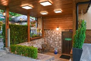 a patio with a building with a stone wall at Hotel Rothmans in Bansko