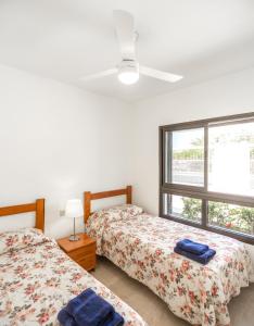 a bedroom with two beds and a window at Villas Las Almenas in Maspalomas