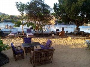 a group of chairs and tables on the sand near the water at جزيره سهيل in Cairo