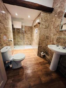 La salle de bains est pourvue de toilettes, d'un lavabo et d'une douche. dans l'établissement Peak Hotel Castleton, à Castleton