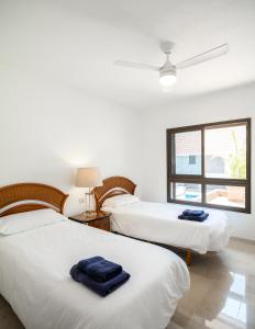 two beds in a room with a window at Villas Las Almenas in Maspalomas