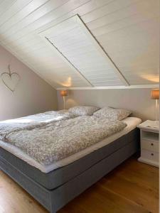 a bedroom with a bed with a white ceiling at Mølleråsen Apartment in Sandefjord