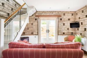 ein Wohnzimmer mit einem Sofa und einer Steinmauer in der Unterkunft The Dovecote - Collins Farm in Bristol