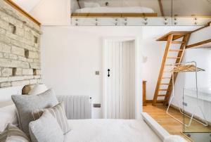 ein Schlafzimmer mit einem Hochbett und einer Leiter in der Unterkunft The Dovecote - Collins Farm in Bristol
