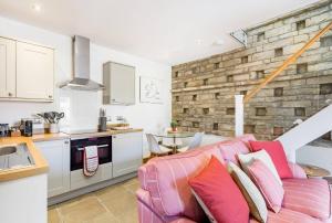 a living room with a couch and a kitchen at The Dovecote - Collins Farm in Bristol