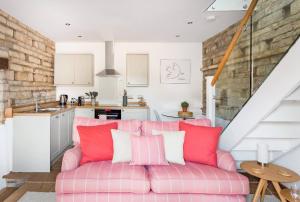 a living room with a pink couch and a kitchen at The Dovecote - Collins Farm in Bristol +6 photos